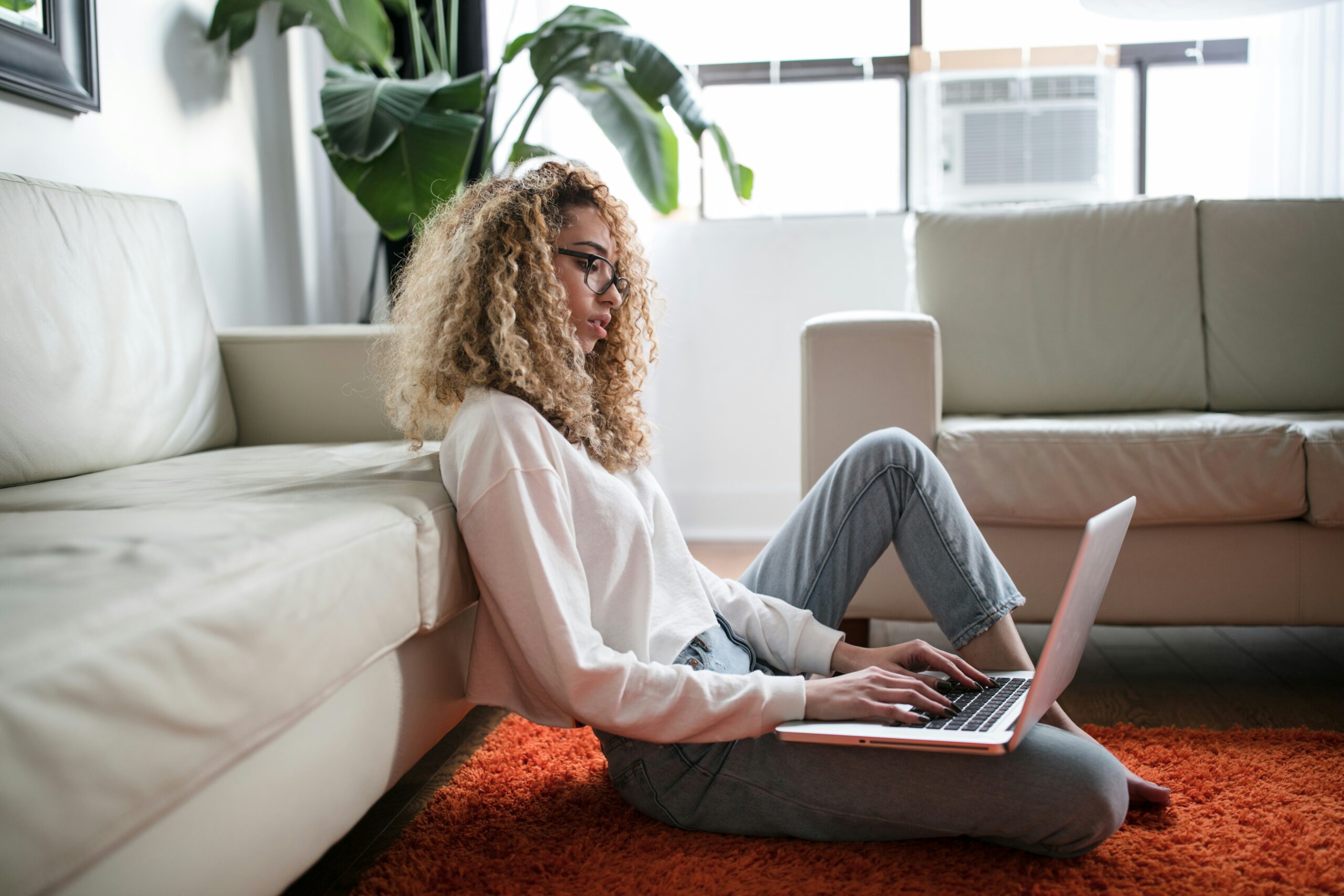 woman-sitting-on-floor-and-leaning-on-couch-using-laptop-scaled Como ganhei dinheiro trabalhando em casa